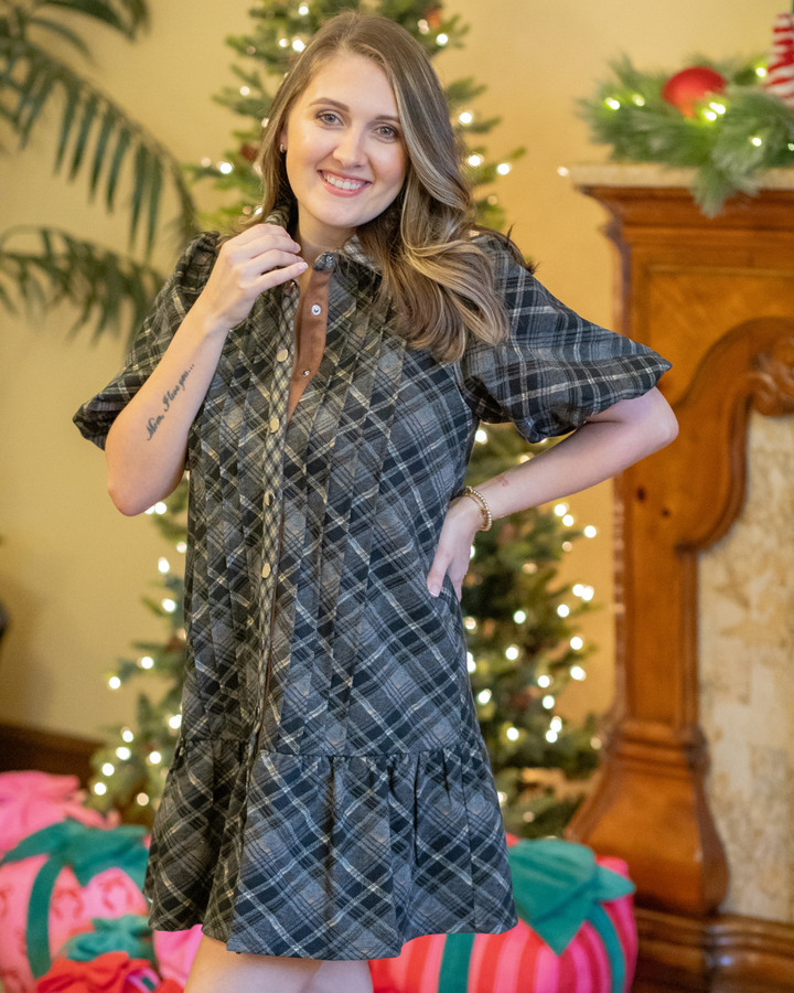 Woman wearing a plaid dress in a festive room with Christmas decorations.