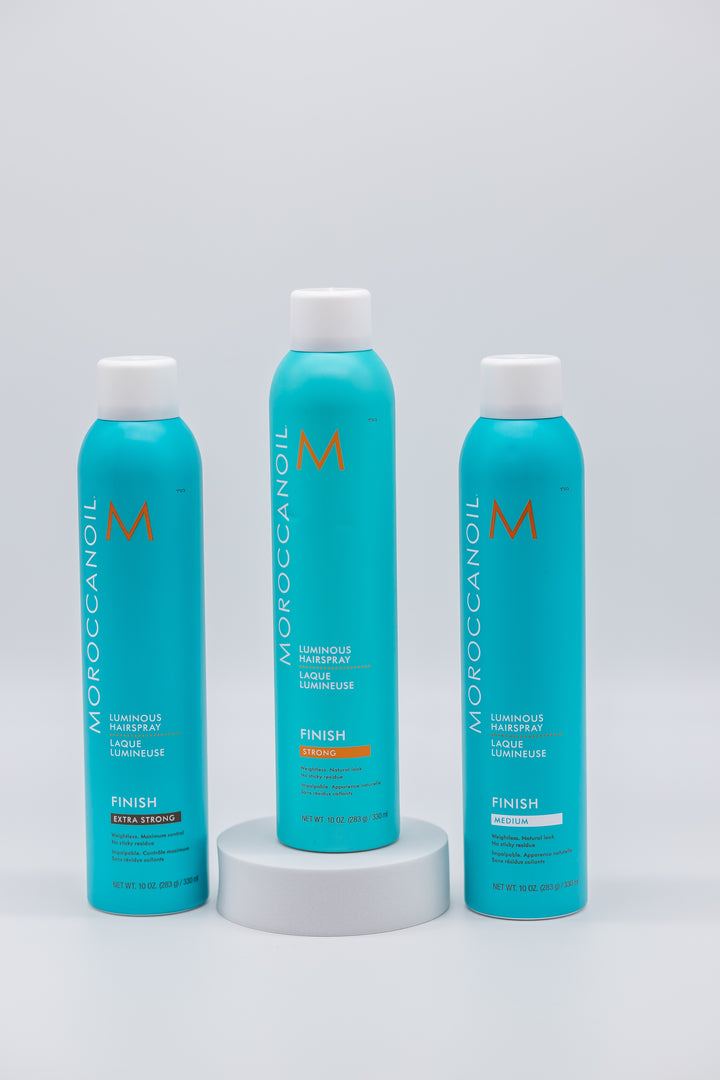 Three bottles of Moroccanoil hair care products on a white background